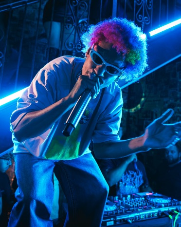 Performer with a microphone under blue neon light